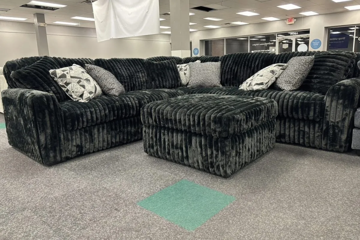 Dark gray sectional sofa on the floor at Elk Grove Mattress and Furniture