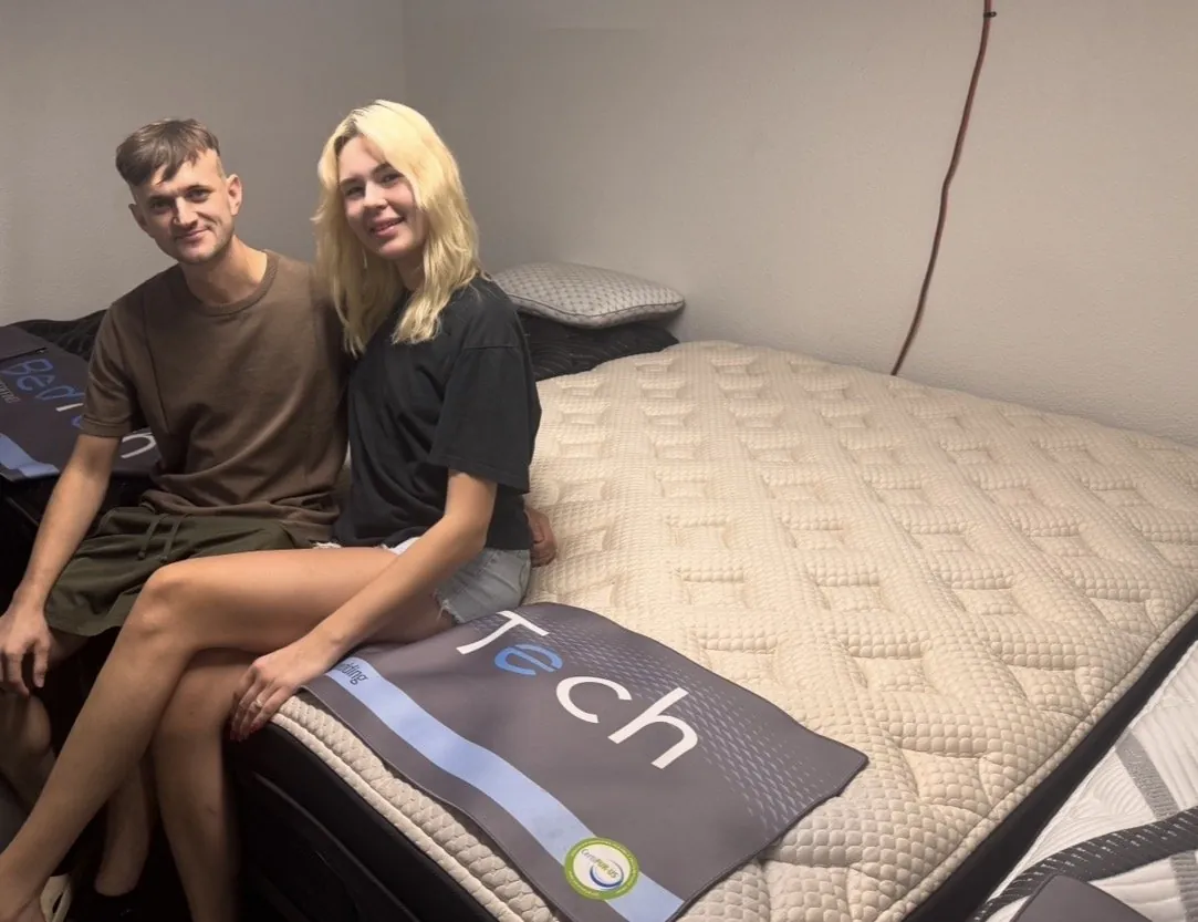Couple sitting on a new mattress at our Elk Grove showroom