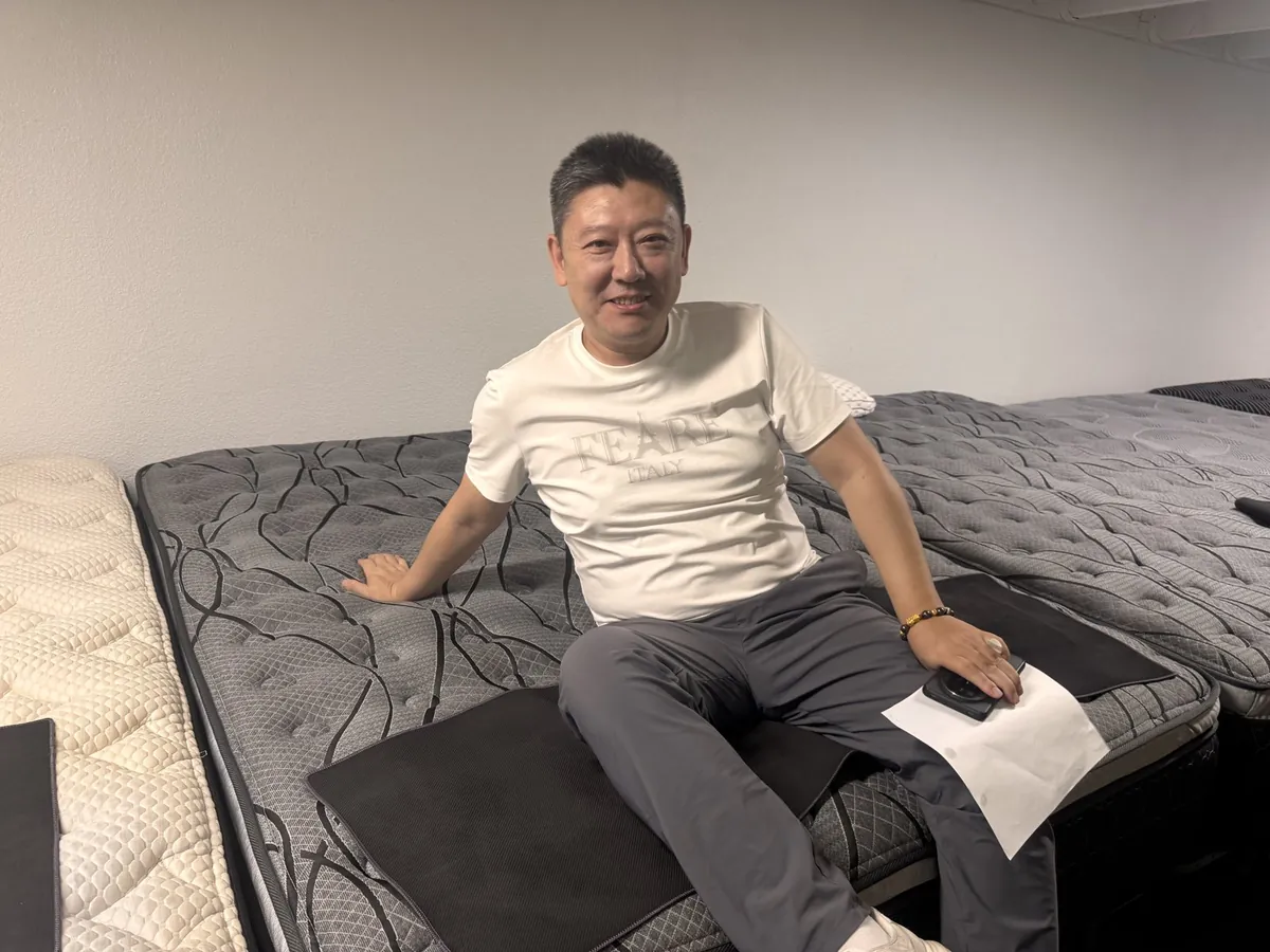 Customer sitting on a mattress at our Elk Grove showroom